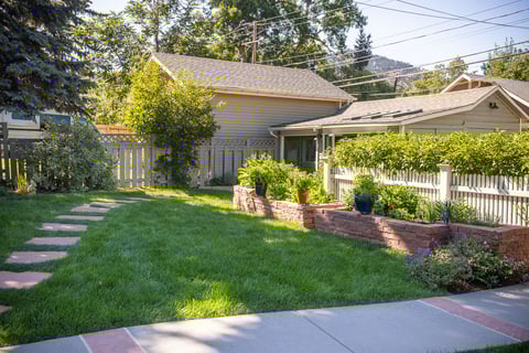 Residential landscape design paver pathway with vegetable garden