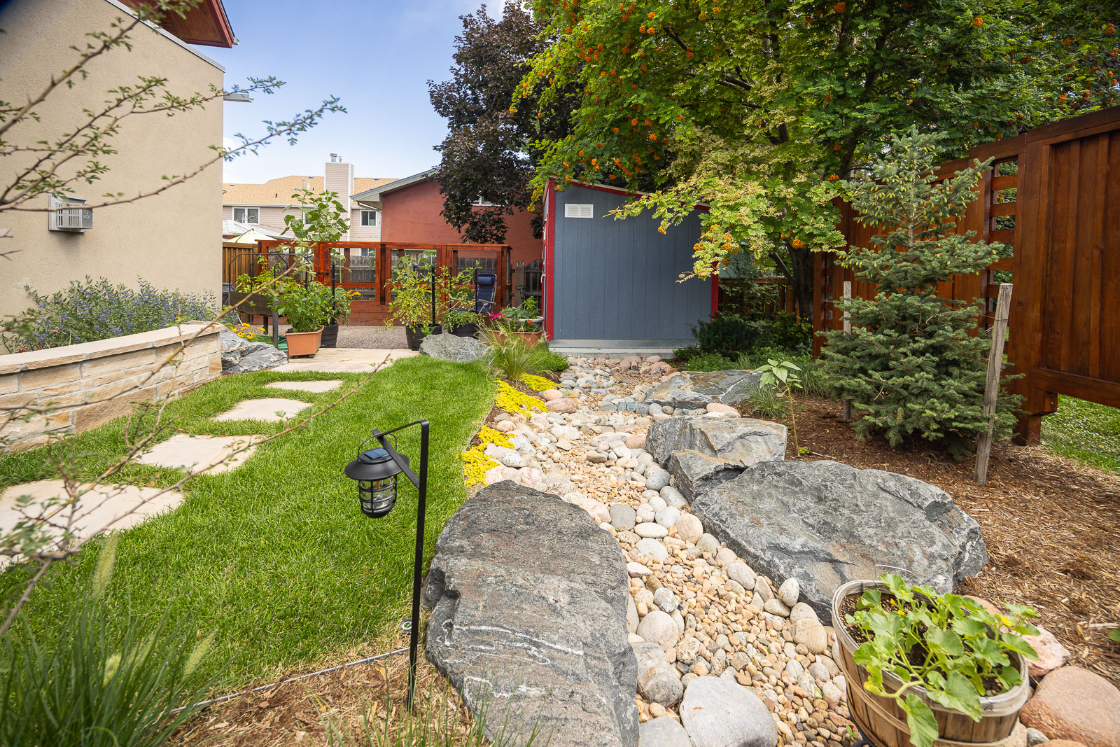 Residential landscape design small backyard paver walkway and water runoff