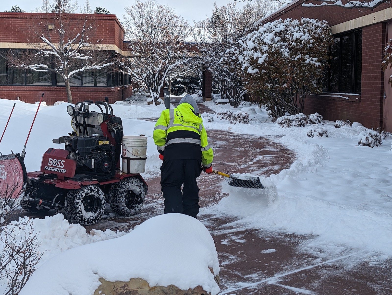 crew removing snow from sidewalks with shovel commercial property 